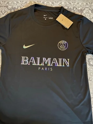 Svart PSG x Balmain t-shirt Nike - Helt ny PSG tröja – aldrig använd, med tag kvar 💯 Stilren svart design med rainbow detaljer, riktigt clean 🔥  Finns i storlekar: S M L