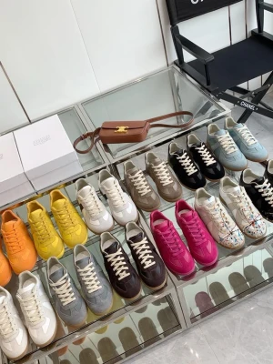 Färgglada sneakers från Maison Margiela - Säljer sneakers från Maison Margiela i flera färger som orange, gul, vit, grå, brun, svart, blå, rosa och röd. Klassisk låg modell med vita snören och gummisula. Materialet är en mix av mocka och läder, vissa med metallic-detaljer eller färgstänk. Perfekta för dig som vill sticka ut.