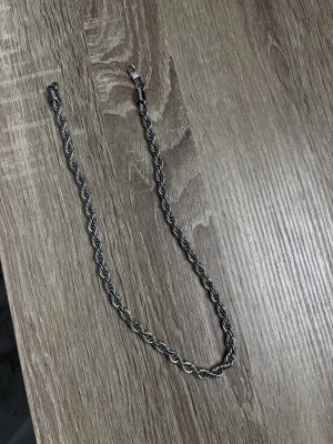Tjockt silverfärgat kedjehalsband - Snyggt halsband i silverfärgad metall med tvinnad kedja som ger en robust och trendig look. Halsbandet har ett klassiskt karbinlås och passar perfekt till streetwear eller för att lyfta en enkel outfit. Inga synliga märken eller loggor. De borde passa alla 