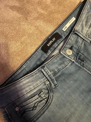 Replay Luzien ljusblå jeans W30 L32 - Snygga ljusblå jeans från Replay, modell Luzien. Klassisk femficksdesign med smal passform och normal midja. Jeansen har diskreta slitningar och är tillverkade i mjukt denimtyg med stretch för extra komfort.