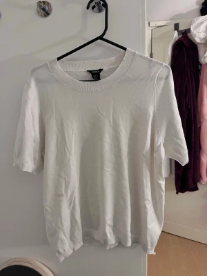 Trekvarts ärmad tröja från Lindex - En vit trekvarts ärmad tröja med rund hals och korta ärmar. Tillverkad i mjuk bomull som känns skön mot huden. Perfekt till alla typer av outfits och lätt att matcha med andra plagg. Finns två fläckar, vet inte och de går bort i tvätt har inte testat men syns inte särsklit mycket
