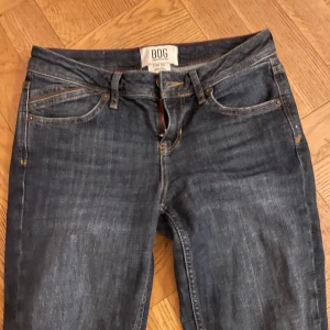 Mörkblå jeans från BDG - Snygga mörkblå jeans från BDG med klassisk femficksmodell och utsvängda ben. Jeansen har detaljerade sömmar på bakfickorna och är tillverkade i ett slitstarkt denimtyg. Perfekta för en avslappnad och trendig look.