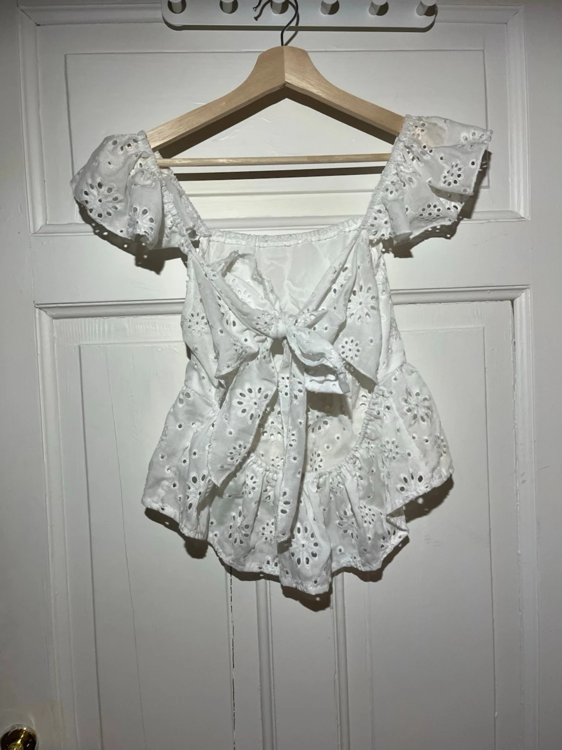 Vit blus med broderade blommor och knyt