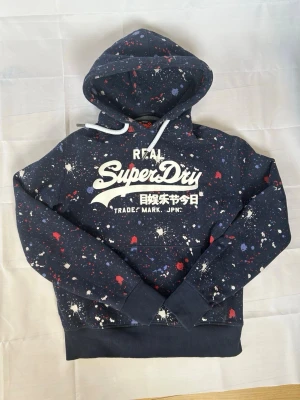 Mörkblå Superdry hoodie vintage - En riktigt fet superdry tröja! Sitter som M passar perfekt och har fint skick. | Skick:9/10 | modellen är 185cm lång‼️ Mått armhåla-armhåla 54cm och armhåla-slut 46cm. Pris 599 men kan diskuteras😁☺️🤩