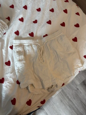 Linne shorts - Luftiga vita shorts i mjuk bomull med snörning i midjan. De har en avslappnad passform och är perfekta för varma dagar. Materialet är lätt och andas, vilket gör dem sköna att bära under sommaren. Använda max 2 gånger så inprincip helt nya.