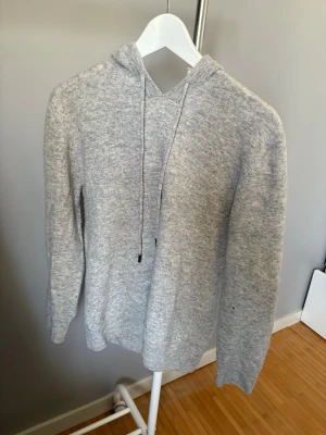 Ljusgrå stickad hoodie - Ljusgrå merinoull hoodie knappt använd. Använt den max 3 gånger. Hör av er vid funderingar 
