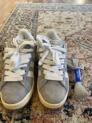 Grå Adidas sneakers i mocka - Säljer dessa grå Adidas Originals sneakers i storlek 39 då de var för små för mig. Har ändats prövat de så är som nya. Ett extra par snören finns även kvar. 💕💕💕