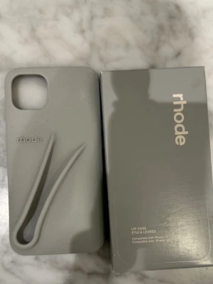 Grått mobilskal från rhode - Snyggt grått mobilskal från rhode i iPhone 13. Jättebra skick köptes från Rhode hemsida i somras🩵