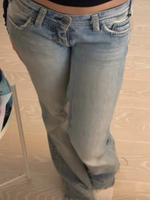 Mavi Lowwaist bootcut jeans - Säljer dessa ljusblåa Lowwaist jeans från Mavi💕   Är nersydda av tidigare ägare och  uppklippta nertill, inget märkbart. Midjemått: 35 cm Innerbenslängd: 78 cm. Defekter: Dragkedjan är söder - fastsydda knappar ist, ett hål på baksidan som går att sy för enkelt!