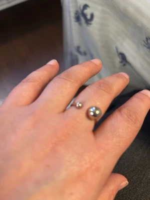 Snygg stål  silverring med två kulor - Minimalistisk stål  silverfärgad ring med öppen design och två blanka kulor i olika storlekar. Ringen har en modern och stilren look som passar perfekt för dig som gillar enkel men unik design. Passar storlek 16 till 18,5 