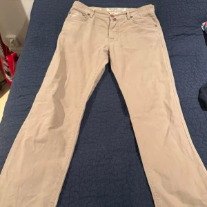 Beiga jeans från cohën - Snygga beiga jeans från cohën med klassisk femficksmodell och raka ben. Jeansen har en läderpatch bak i midjan och silverfärgade nitar. Tillverkade i bomull för en skön känsla och stilren look.