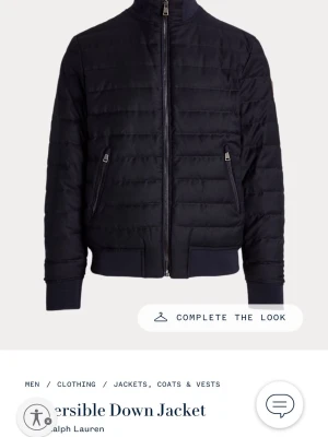 Ralph Lauren reversible down jacket - Snygg navy reversible down jacket från Polo Ralph Lauren med quiltad design och hög krage. Jackan har två dragkedjeförsedda fickor framtill, ribbade muddar och nederkant samt hel dragkedja. 