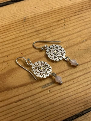 Mandala örhängen - Söta små örhängen i silver formade som mandalas med glittriga stenar och rosa pärlor.