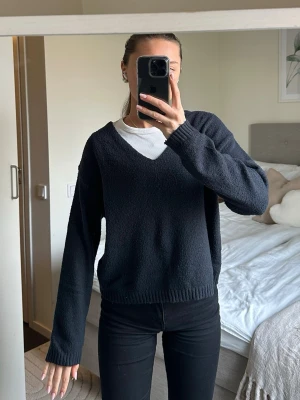 Mörkblå stickad V-ringad tröja - Mysig mörkblå stickad tröja med V-ringning och långa ärmar. 