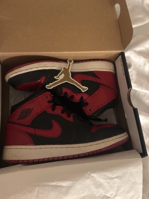 Air Jordan 1 Mid Banned - Säljer ett par Air Jordan 1 Mid sneakers i klassisk svart och röd färgkombination med vita sulor, modellen heter Banned. Dom är använda men fortfarande i bra skick. Kom privat för fler bilder. Nypris över 2000