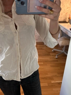 ”Fitted” skjorta - Klassisk vit skjorta med långa ärmar och knappar framtill. Skjortan har två bröstfickor och är tillverkad i ett lätt bomullstyg. Passformen är normal och skjortan är enkel att styla till olika looks.