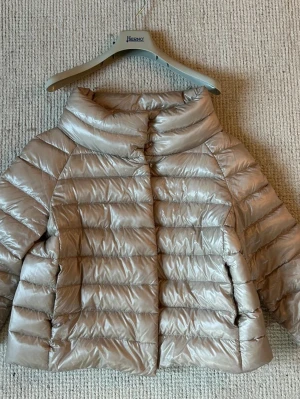Beige trekvarts vårjacka från Herno - Snygg beige trekvarts vårjacka från Herno med hög krage och kort, boxig passform. Jackan har horisontella sömmar och stängs med tryckknappar framtill. Perfekt för kalla vinterdagar och ger en stilren look. I storlek