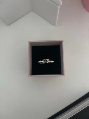 Silverfärgad ring med taggar  - Stilren silverfärgad ring med fem små taggar i rad på ovansidan. Ringen har en slät och enkel design som passar till många olika stilar. Perfekt accessoar för dig som gillar minimalistiska smycken.