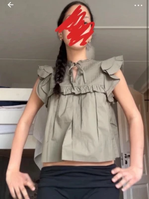 Khakigrön volangblus  - Supersöt khakigrön blus från Gina tricot med volangdetaljer vid axlarna och knytning i halsen. Blusen har en lös passform. Perfekt för dig som gillar en avslappnad men ändå trendig stil.