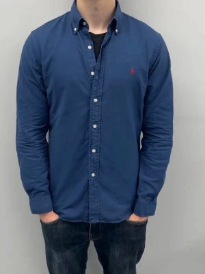 Ralph lauren skjorta - Ralph lauren skjorta size M bra skick lite använd och ända defekten är att underarmen är lite använd och har lite tecken men inget stort om man har den på | måste strykas!  Bild ett är ungefär så det ser ut fast färgen på loggan är mer rosa på riktiga men likt