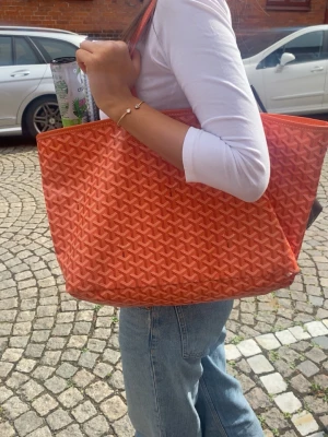 Orange shoppingväska  - Säljer en stor orange shoppingväska. Väskan har en rymlig form och är tillverkad i canvasmaterial med två axelband. Perfekt för resande och skola 💗VILLIG ATT DISKUTERA PRIS!
