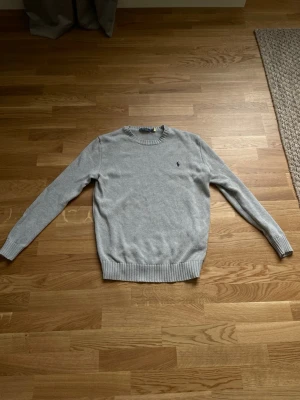 Ljusgrå stickad tröja Polo Ralph Lauren - Snygg ljusgrå stickad tröja med rund krage från Polo Ralph Lauren, Inte många tecken på användning, fraktas inom 24 timmar efter köp📦