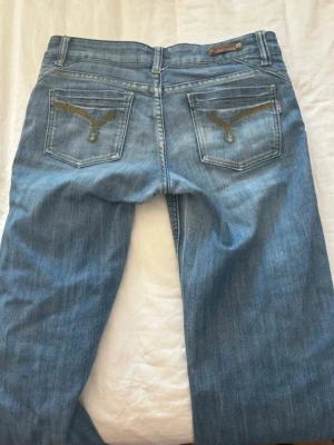 Blåa jeans från  C.T.M  - Snygga blå jeans från C.T.M med lite bootcut och klassiska fickor. Baktill finns små fina detaljer. Jeansen är i mjukt denimtyg och har låg/normal midja. Perfekta för en avslappnad och trendig look.