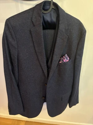 J.Lindeberg tredelat kostymset - Kostymset i tredelar, size 48R.                       Använd en gång.                                                 Modell på bilden är 182 cm och väger ca 75 kg, den är lite för tight för mig.                                            Näsduken ingår inte