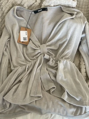 Grå långärmad tröja - Säljer en jättefin grå/beige topp från Bikbok. Den är köpt på sellpy och i bra skick.