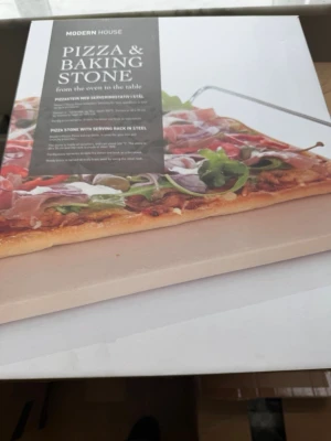 Modern House pizzasten med ställ - Säljer en pizzasten från Modern House som även funkar som baksten. Stenen är ljusbeige och kommer med ett serveringsställ i stål. Perfekt för att baka pizza eller bröd hemma och få en krispig botten. Levereras i originalförpackning.