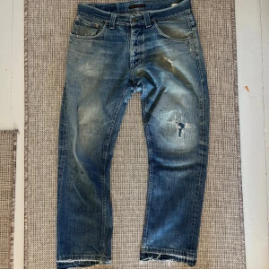 Blå raka jeans med slitningar - Säljer ett par galet feta nudies med lagningar. Väldigt gamla så står tyvärr inte modell eller storlek men skulle gissa på 31. De sitter lite lösare.