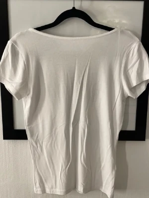 T-shirt  - En T-shirt med öppen rygg. Knap andvänd 