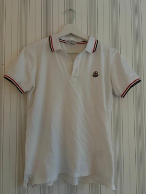 Moncler pike - Vit moncler piké perfekt för dig som gillar en stilren look, perfekt för vardagen och för dig som gillar exklusiva kläder