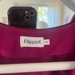Rosa klänning från Filippa K - Snygg rosa klänning från Filippa K i storlek XS. Klänningen har en avslappnad passform, vida ärmar. Tillverkad i ett mjukt och lätt material som känns skönt mot huden. Perfekt för sommaren. 