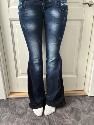 Mörkblåa jeans med ”ALTADENIM” - Så snygga mörkblåa väldigt low waist jeans med ”ALTADENIM” broderat på😍Jeansen är bootcut och inte av stretchmaterial. Måtten är: innerbenslängd - 87 cm, midja - 80 cm och lårvidd - 46 cm💙strl S är en uppskattning!! Så mät måtten på dig själv för att vara säker på att de passar!!