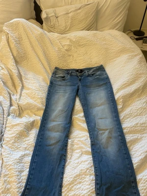 Blå bootcut jeans från LTB - Snygga blå bootcut jeans från LTB med klassisk femficksdesign och ljusa slitningar framtill. Jeansen har låg midja och är tillverkade i denim med lite stretch för extra komfort. 