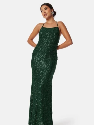 Balklänning!! - Säljer en elegant mörkgrön långklänning med smala axelband och glittrigt material. Klänningen har en figurnära passform och är perfekt för speciella tillfällen. Materialet är troligtvis polyester och klänningen har en stilren, modern look. Köpt på Nelly och använd endast en kväll