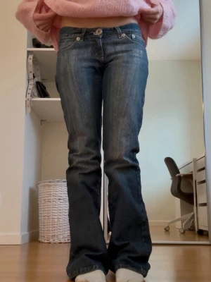 Blå bootcut jeans med låg midja - Midjemått: 36 cm, innerbenslängd: 79 cm 