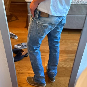 Ljusblå raka jeans från Diesel  - Säljer ett par ljusblå jeans från True Religion med raka ben och klassiska kontrastsömmar. Jeansen har fem fickor, slitna detaljer och broderad logga på bakfickan. Perfekta för en avslappnad och trendig look.