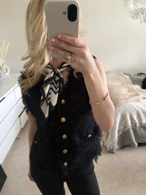 Svart topp med guldknappar - Superfint svart topp med guldknappar i materialet bouclé! 
