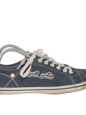 Marinblå Tom Tailor sneakers - Snygga marinblå sneakers från Tom Tailor med vita kontrastsömmar och vita snören. Skorna har lågt skaft och klassisk design med logotyp broderad på sidan. Yttermaterialet är textil och sulan är vit med en tunn rand i beige.