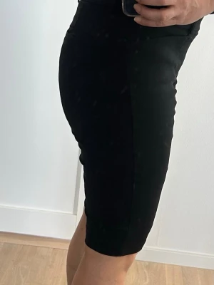 Svarta shorts Callaway Stl M Dam - Svarta shorts med tight passform och knälångt snitt och hög midja. Tillverkade i ett stretchigt material som ger bra rörelsefrihet, perfekta för en golfrunda. Endast använda en gång. Stl M 