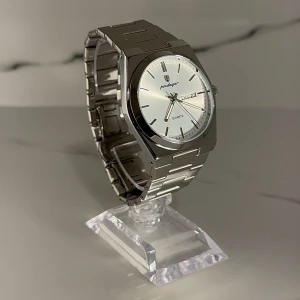 Premium Silverfärgad Klocka 40 mm - Stilren herrklocka med silverfärgad länk i metall och vit urtavla. Klockan har dag- och datumvisning samt tydliga indexmarkeringar. Klassisk design som passar till många tillfällen. BOX, ALLA LÄNKAR och LÄNKJUSTERARE MEDFÖLJER! PRISET KAN DISKUTERAS VID SNABB AFFÄR!