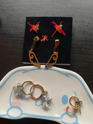Guldörhängen i olika format - Vingarna- lite smårepor men som knappts syns - 50kr.  Glitter Guldringar i äkta platterat guld 60kr (dock ena ploppen som försvunnit ersätter med en kopparplopp) UO Fjärilsörhängen, inte bästa kvale och på ena örhänget är ögglan lite sne vilket gör så fjärilen sitter lite sne(kan fixas med tång själv) 30kr. Frågor? Kom Dm eller köp billigare i paketpris!                                 
