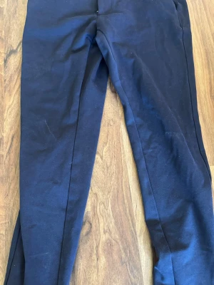 Mörkblå kostymbyxor Only & Sons - Snygga mörkblå kostymbyxor från Only & Sons med smal passform och klassisk design. Byxorna har pressveck och är tillverkade i ett mjukt tyg som ger en stilren look. Perfekta för dig som vill ha en clean och modern stil.