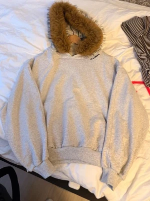 Grå hoodie med fuskpäls från Scuffers - Säljer en grå hoodie från Scuffers med mjuk fuskpäls runt huvan. Nypris ca 1000kr. Slå ett PM för fler bilder, pris går att diskuteras.
