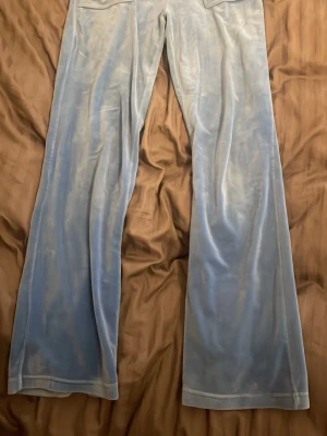 Ljusblåa velour mjukisbyxor - Säljer ett par ljusblå mjukisbyxor (Jucy couture) har andvända få antal gånger, dom är i ett fint skick men ena metall brickan på snöret har lossnat men inget man tänker på särskilt mycket. Pris kan diskuteras 