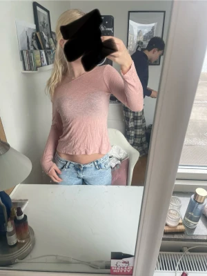 Ljusrosa croppad långärmad topp - Trendig ljusrosa croppad topp med lång ärm och offshoulder-design. Tunt och lätt material.