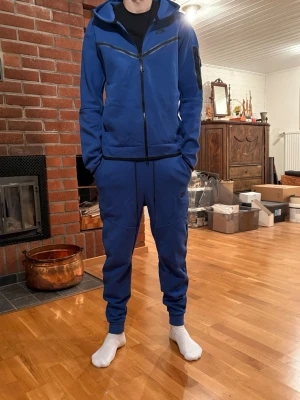 Blå Nike tech set - Säljer mitt Nike tech set pågrund av att de inte längre används. Hoodie och byxor kan köpas separat. Hör av er vid funderingar.