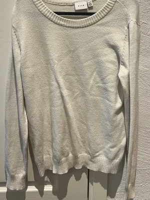 VILA vit tröja, storlek M - En stickad vit tröja med långa ärmar och rund halsringning från VILA. Tröjan har ribbade muddar i ärmslut och nederkant. Mycket gott skick!!